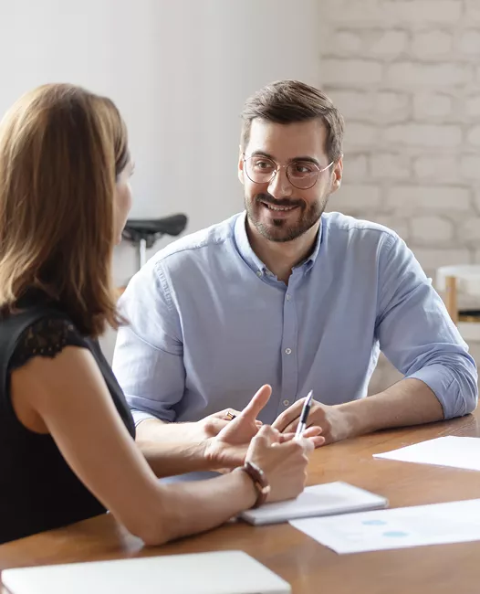 two seated people talking in an office